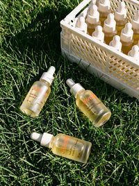 Youth Elixir bottles on sunlit grass
